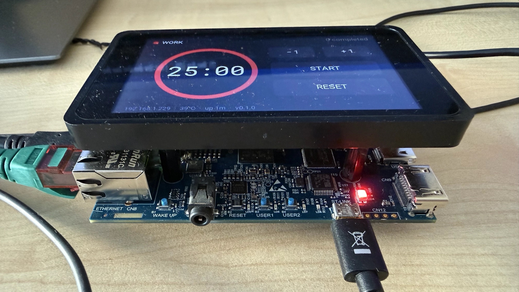 The STM32MP157F-DK2 with its 4-inch MIPI DSI panel attached — ST-LINK, Ethernet and the USER buttons visible along the front edge